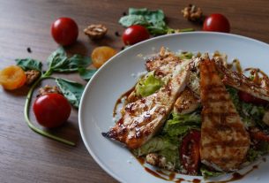 Delicious grilled chicken salad served with fresh tomatoes and walnuts on the side.